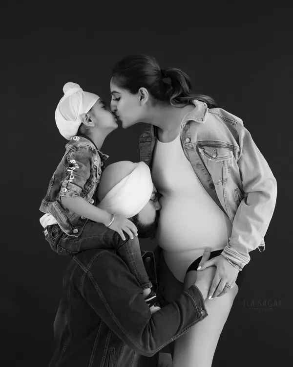A timeless black and white portrait celebrating a growing family. This image captures the love and excitement as they await their new arrival.