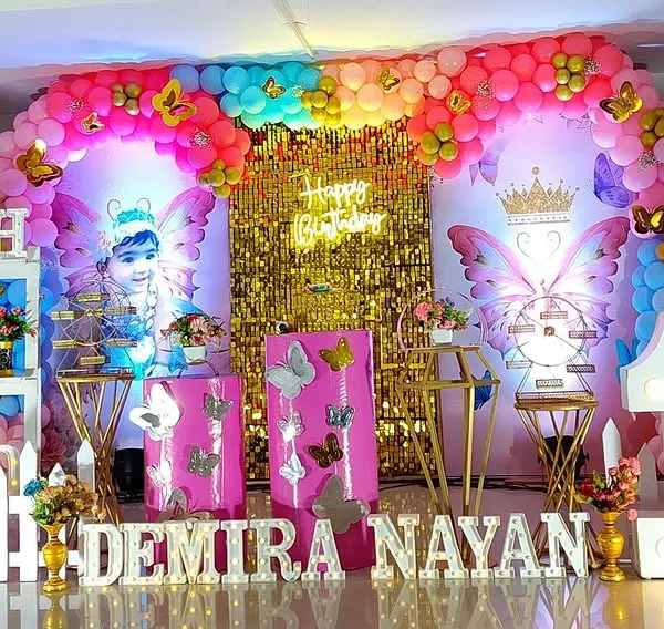 This grand butterfly-themed birthday is one of my favorites, featuring a gold sequin backdrop, large butterfly wing props, and a colorful balloon arrangement for a truly spectacular celebration.