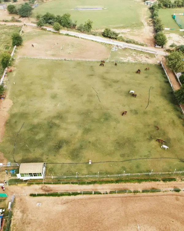 An aerial drone shot of my entire property, showing the main riding field, the practice arena, and the surrounding natural landscape.