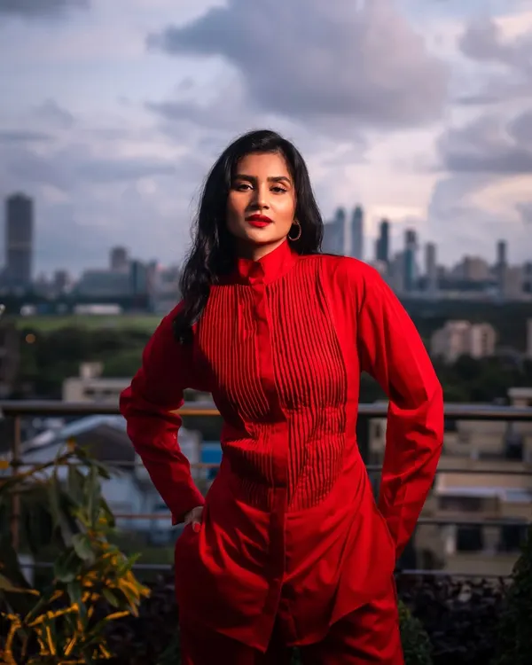A powerful portrait from a rooftop photoshoot in Mumbai. The bold red outfit stands out against the city skyline, creating a striking and confident image.