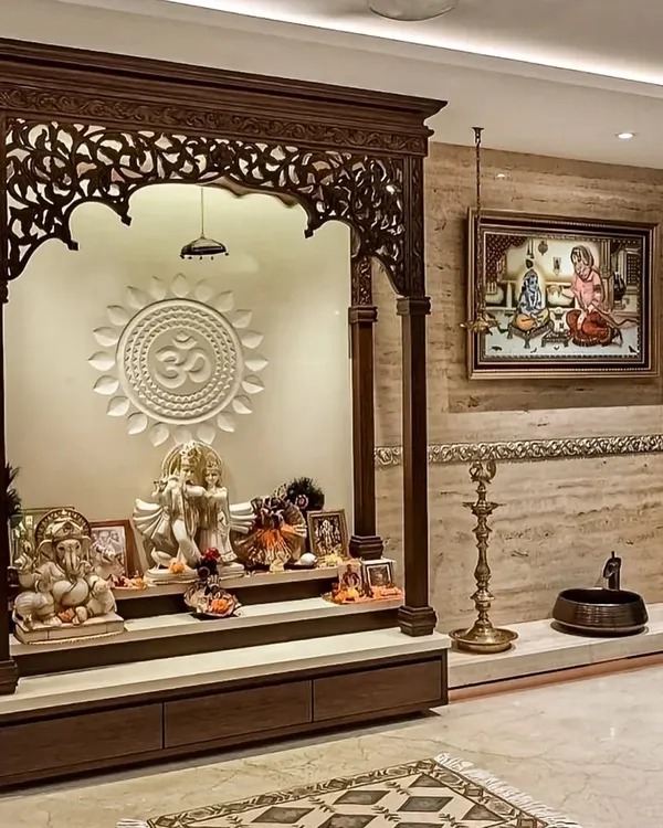 A magnificent, traditional pooja mandir crafted from dark wood with intricate carvings. This freestanding unit features a raised platform, storage drawers, and a beautifully detailed arch, creating a grand and sacred space.