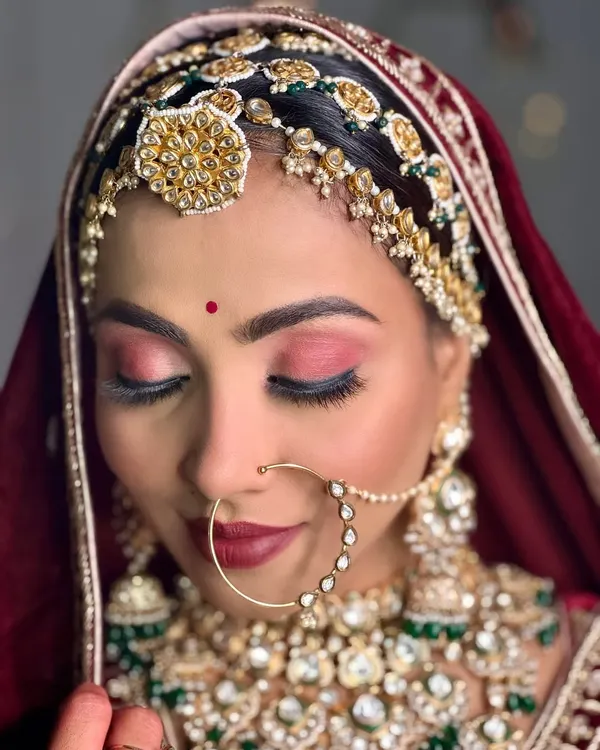 A close-up of my royal Marwadi bride. The focus here is on the rich, rosy eyeshadow and deep red lip, which perfectly complements her traditional jewellery and attire.