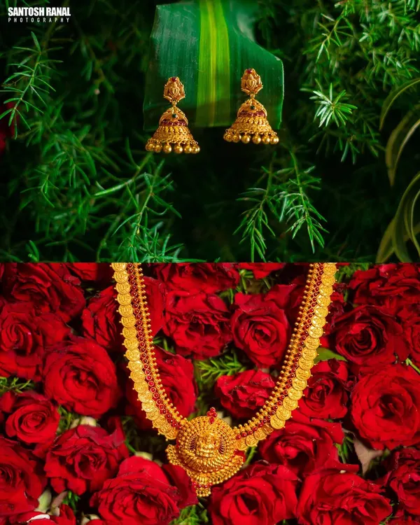 A creative product shot of traditional gold temple jewelry, beautifully arranged on a bed of red roses to evoke a sense of romance and luxury.