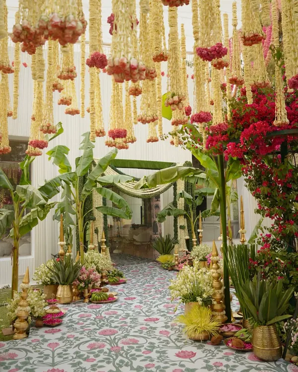 This stunning entrance walkway is designed for a traditional South Indian wedding. I used hanging garlands of tuberose and marigolds, flanked by banana trees and brass pots, to create a festive and auspicious welcome for guests.
