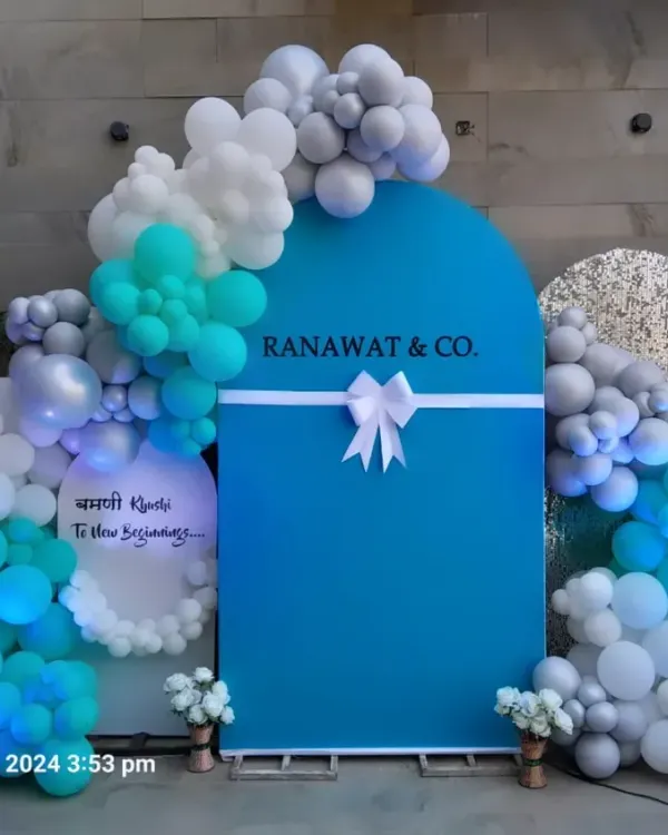This branded arch for Ranawat & Co. uses their signature blue color, framed by a stylish balloon arrangement in teal, white, and grey. It's a great way to welcome guests to a new office opening or brand launch.