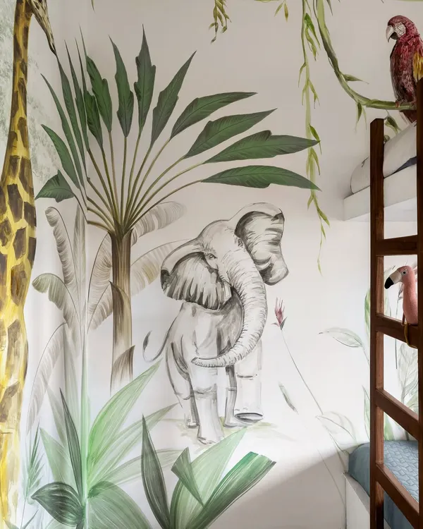 A close-up of the hand-painted jungle mural, a centerpiece of this child's room. We collaborated with a local artist to bring the safari to life, turning the walls into a canvas for adventure.