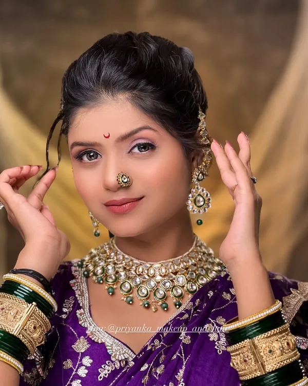A close-up of a classic bridal look in a purple Paithani saree. The focus is on radiant skin, expressive eyes, and traditional jewelry like the nath and choker, perfect for a Marathi bride.
