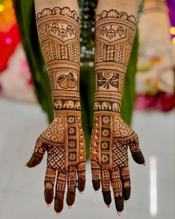 This is a classic full-coverage bridal design featuring traditional Indian motifs like elephants and temple domes (gumbad), with detailed checkerboard patterns on the fingers.