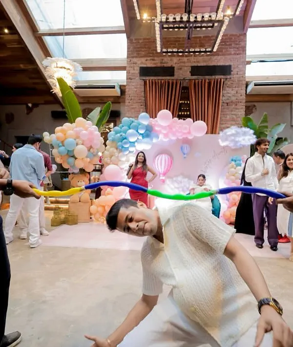 It's not a baby shower without some fun and games! Here, guests are having a great time playing limbo, bringing a ton of laughter and energy to the party.