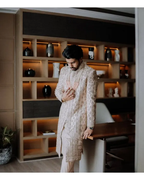 A portrait of the groom, looking sharp and sophisticated in his sherwani, captured in a moment of quiet reflection before the ceremony begins.