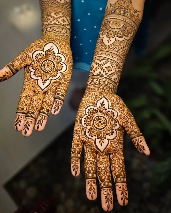 This full-hand bridal design is a perfect example of my passion for intricate work. The central mandala is created with bold lines and delicate details, while the fingers and forearm feature a mix of traditional patterns, all drawn with my handmade, natural henna.