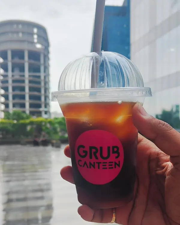 A real-life shot of my Iced Americano, perfect for a hot Noida day. This shows a customer enjoying a refreshing cold coffee against the backdrop of the city.
