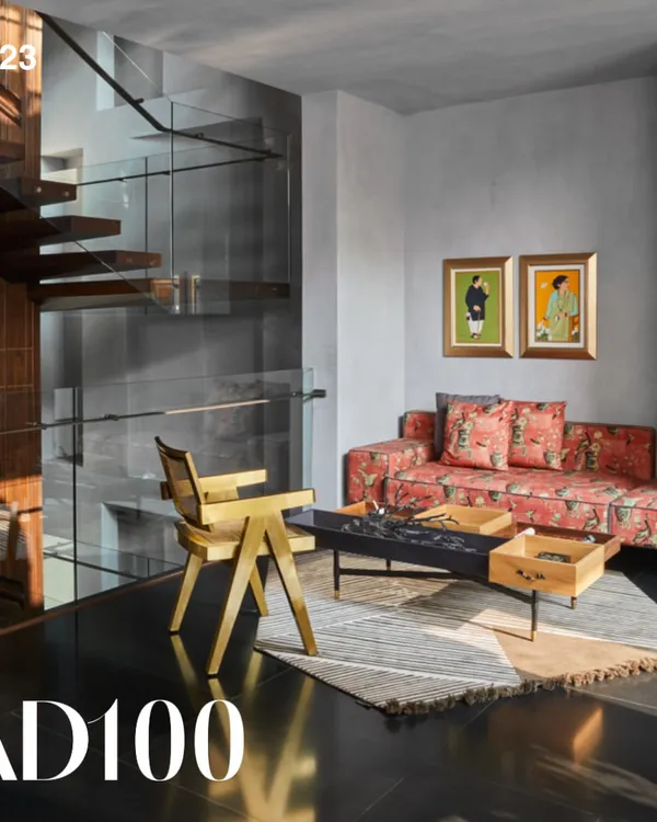 A lounge area from our AD100 award-winning Baid Residence. This space features a custom sofa, a brass chair by Mahendra Doshi, and a coffee table from Mogg Design, all set against sleek black granite flooring.