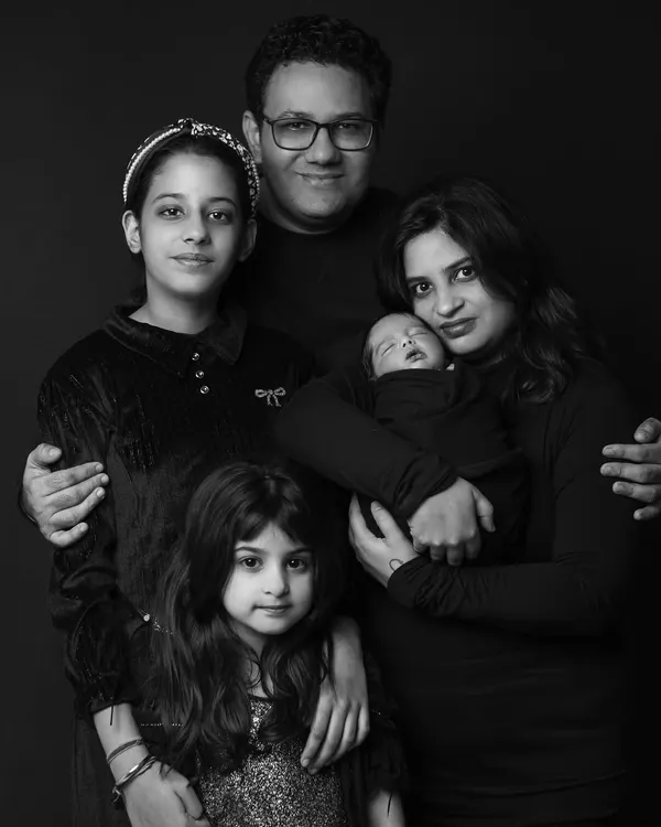 This classic black and white portrait captures a beautiful family of five welcoming their newest member. I work to make everyone feel comfortable, creating a timeless image that shows the unique bond your family shares.