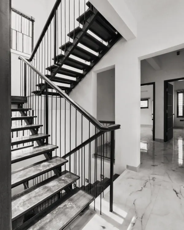 This floating metal staircase is a sculptural, light-filled entity that gives the home its life. Instead of a bulky structure, we designed it to be a focal point that is both functional and artistic.