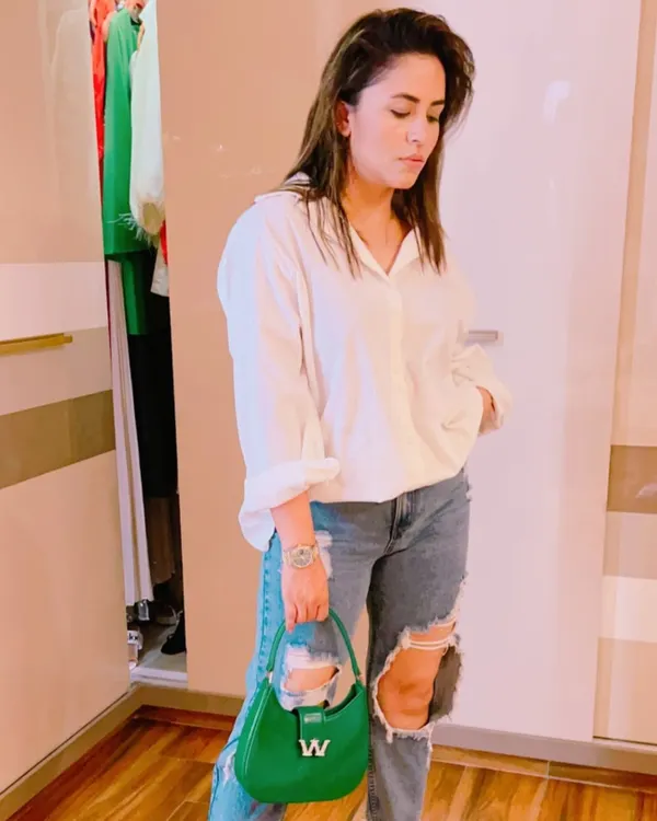 The classic white shirt and ripped jeans combination is a timeless look. I elevated it here with a pop of color from a structured green handbag, showing how accessories can refresh a wardrobe staple.