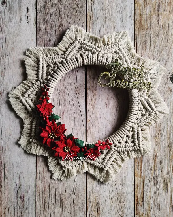 This macrame Christmas wreath is beautifully handcrafted and adorned with red poinsettia flowers. It's a perfect addition to your Christmas decor, great for your door or entryway. It's made with cotton cords on a wooden ring, making it a sustainable choice.