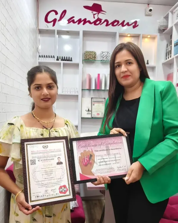 Another student proudly displaying her government-approved certificate alongside her course completion certificate. She is now a certified nail technician, ready for new opportunities.