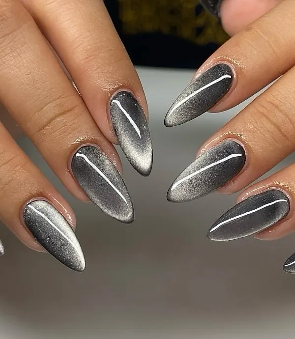 Sleek, sharp, and impossibly cool. This set of stiletto nails features a silver cat eye effect, creating a striking metallic line that shifts and glows against the dark, moody base.