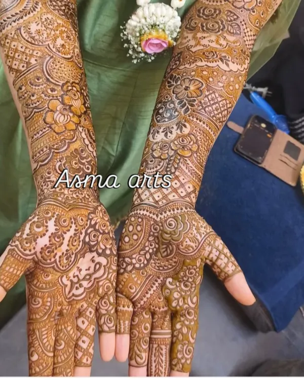 A full-coverage bridal design showcasing intricate floral and paisley patterns that extend from the wrist to the elbow for a classic, elegant look.