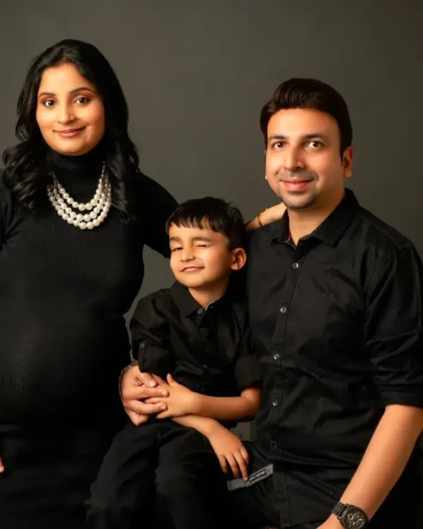 A beautiful family portrait with everyone dressed in classic black. Our fitted maternity dress ensures you look elegant while celebrating with your loved ones.