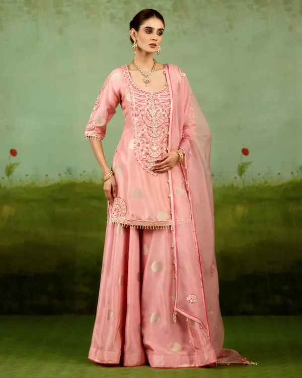 This pink sharara set is both playful and refined. The fluid lines of the sharara pants combined with the intricately embroidered kurta create a look that brings modern ease to festive elegance, perfect for a sangeet or mehendi.