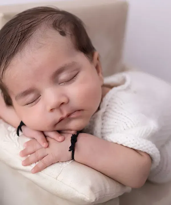 A close-up of pure serenity. I focus on capturing the peaceful expressions of a sleeping newborn, highlighting the delicate features that you'll want to remember forever. This is a classic pose from my newborn portrait sessions.