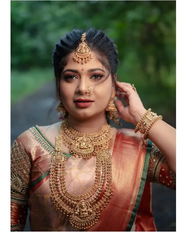 A breathtaking portrait of a bride in a traditional South Indian look. The focus is on her intricate temple jewellery and flawless makeup, capturing the elegance and heritage of her style.