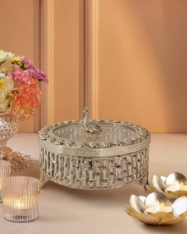 This silver-plated dry fruit box is a masterpiece of intricacy. I designed it with a lattice-work body and a regal peacock knob, making it as much a decorative treasure as a functional serving piece.