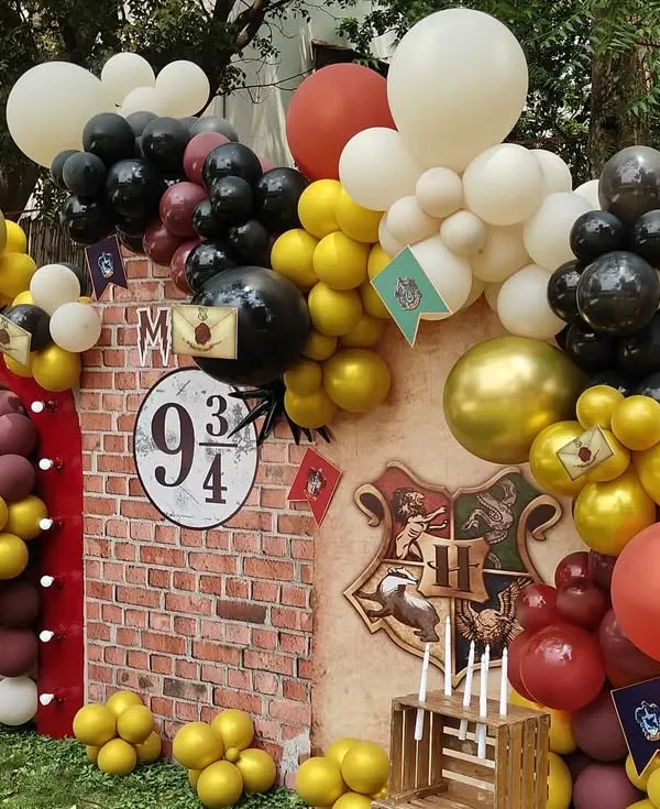 A detailed look at the Harry Potter backdrop, featuring the iconic Platform 9 3/4 sign and Hogwarts house flags.