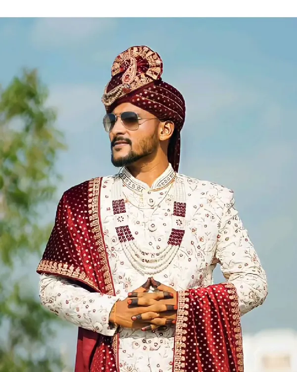 Be the groom that looks his regal best. Our client looks stunning in this classic ivory sherwani with maroon accessories, a perfect royal look for the D-day.
