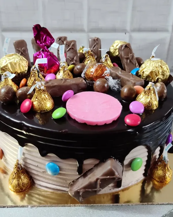 A chocolate overload cake that's pure indulgence. It's loaded with Ferrero Rocher, Hershey's Kisses, M&Ms, and a variety of other chocolates.