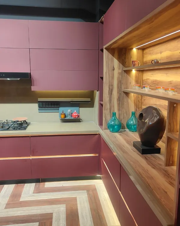 A closer look at the details of our modern magenta kitchen. The handle-less cabinets create a seamless look, while the open wooden shelving unit with integrated lighting provides a warm contrast and a beautiful display area.