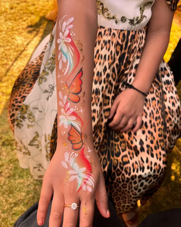 A beautiful cascade of butterflies and flowers painted on the arm. This is a stunning piece of wearable art for any occasion.
