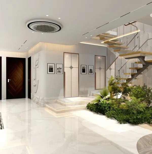 The entrance foyer of this Vasant Vihar residence sets a tone of luxury and biophilic design. A floating staircase rises above an indoor garden, complemented by textured walls and polished marble floors for a grand first impression.