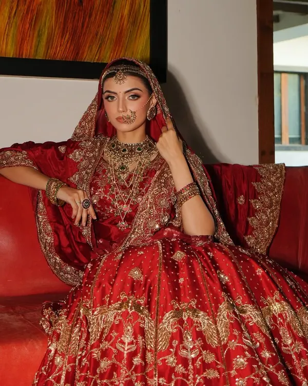 A bride seated like royalty. This classic red lehenga by Akriti by Shakun, paired with heavy traditional jewellery from Shri Paramanijewels, creates a powerful and timeless bridal portrait.