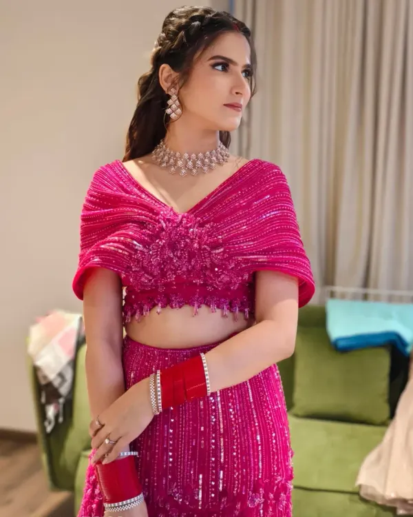 A radiant look perfect for a Sangeet or reception, featuring soft glam makeup with a defined eye and a neutral lip. The intricate braided half-up hairstyle complements the modern pink lehenga, creating a stunning, youthful, and celebratory vibe.