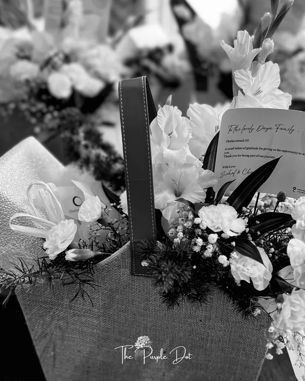 A black and white shot of a thank-you hamper. This classic composition of white flowers in a jute bag shows that even in monochrome, the elegance and personal touch of my work shines through.