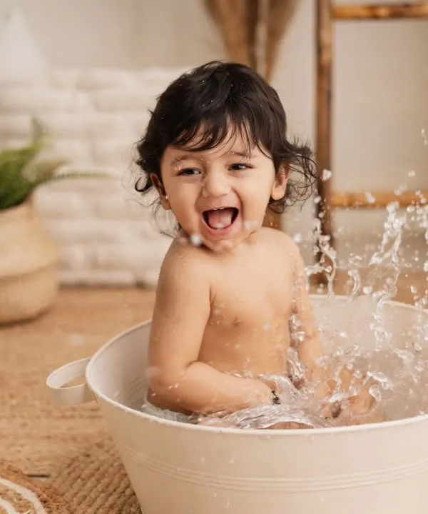 The best part of a birthday shoot? A fun splash in the tub afterwards! This little guy is having the time of his life, and his joyful expression is priceless.