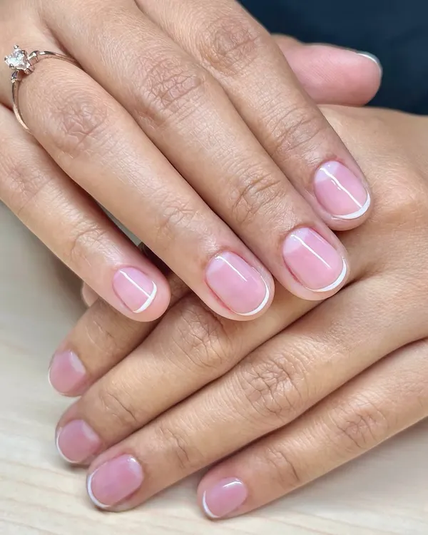 A classic and clean look. This is a simple French manicure on short, natural nails, finished with a glossy gel polish for a healthy shine.