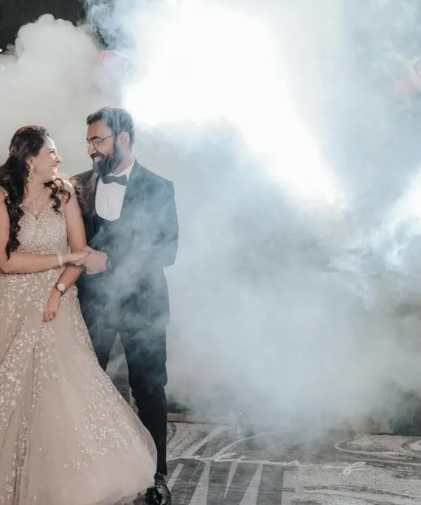 The couple's grand entrance for their first dance, surrounded by dramatic smoke. A truly cinematic moment from their cocktail night.