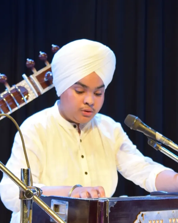 A young student performs on the harmonium as part of a group kirtan in Raag Bhairavi.