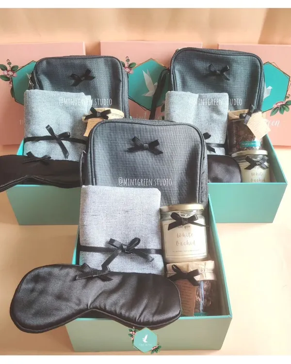 Appreciating a team with matching hampers. These boxes include a travel pouch, a soft towel, a scented candle, and an eye mask, perfect for helping them unwind after a big project.