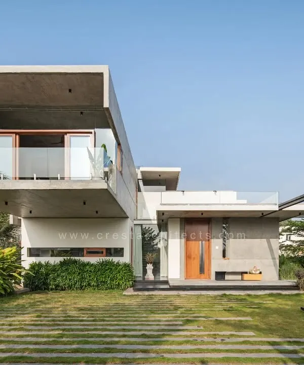 The Quarry House, defined by its bold 18-foot cantilevered concrete volume. The design creates a powerful architectural statement while maintaining a harmonious relationship with the surrounding lawn and linear stone pathways.