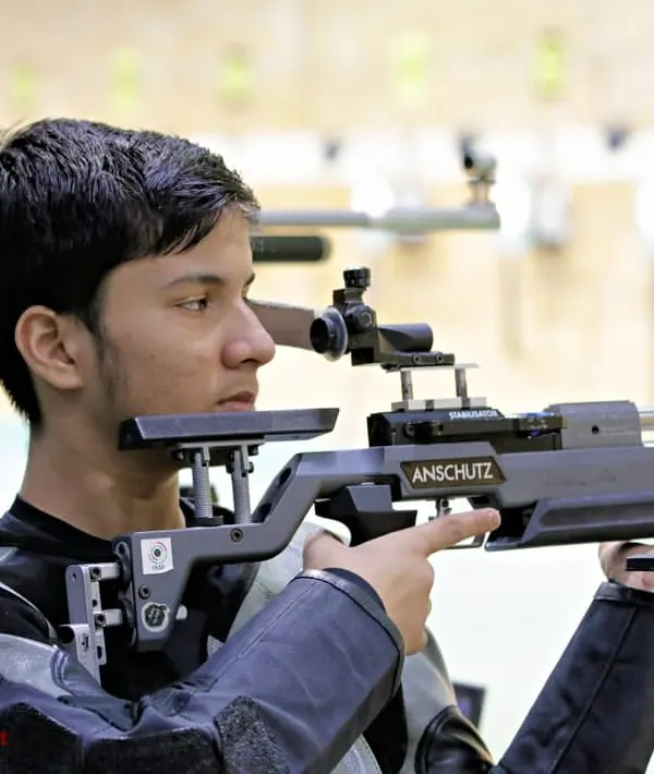 The intense focus of a young rifle shooter lining up his shot. We teach the breathing techniques, posture, and mental calmness required for precision shooting.