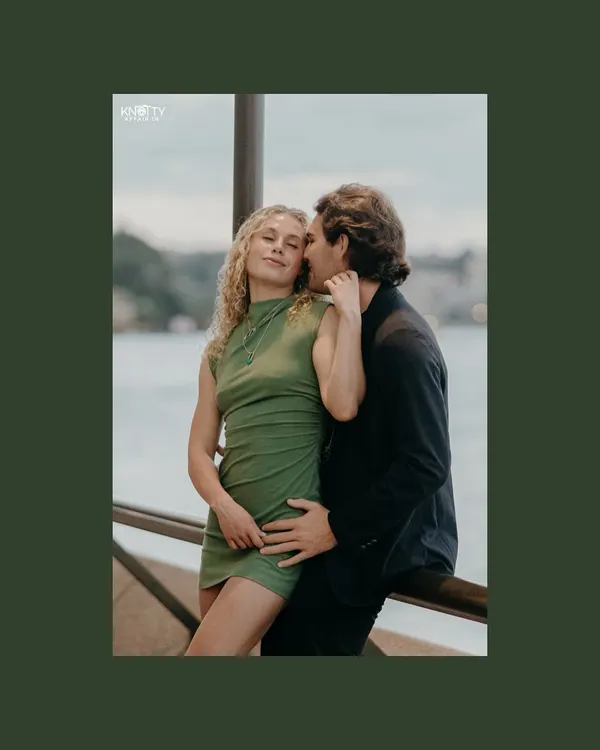 An intimate portrait from a pre-wedding shoot in Australia. The dark green border frames the couple, drawing the eye to their tender and affectionate embrace by the water.