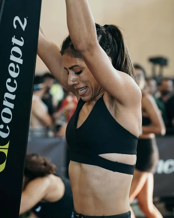 The pain face is real. This is me on the rower during a HYROX race, a moment that tests your cardiovascular endurance and mental fortitude. Every pull is a battle, and my training prepares you to win it.