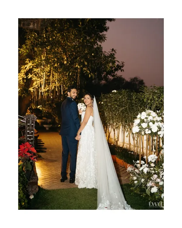 A beautiful portrait of a Catholic bride and groom, walking hand-in-hand in a garden after their ceremony. A picture of serene and happy love.