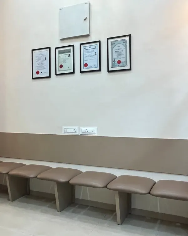 The patient waiting area provides a comfortable and private space for you before your appointment. You can see my qualifications and certifications displayed, reflecting my commitment to expert care.