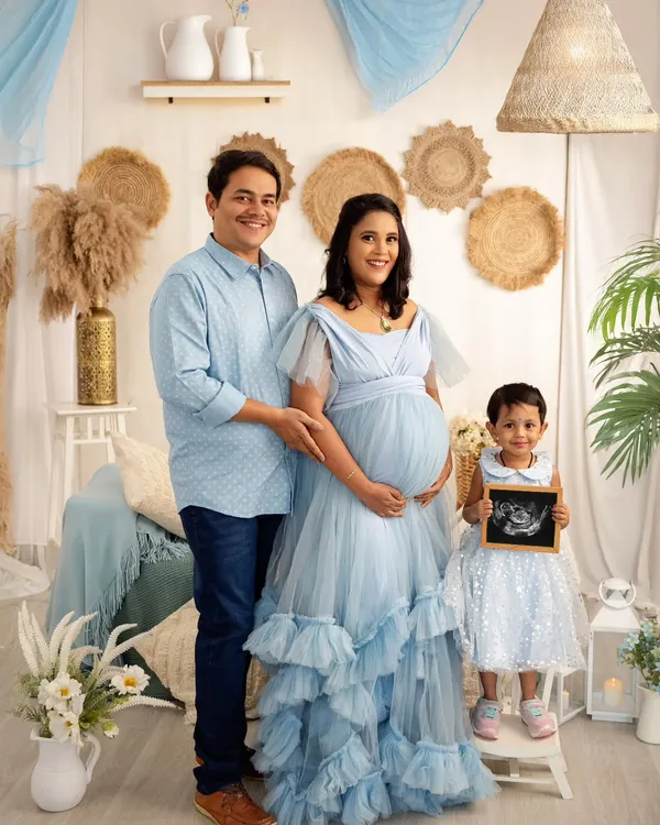 This is what a family's dream looks like. We created this beautiful boho-themed maternity session in my studio, complete with soft textures and natural elements to celebrate the upcoming arrival. The older sibling is just as excited, holding the sonogram that started it all.